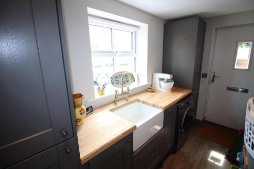 a kitchen with a sink and a window at The Angel Holiday House in Warminster