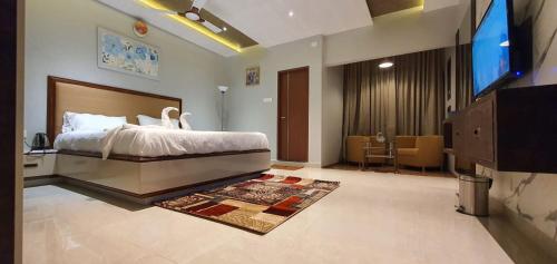 een slaapkamer met een bed en een flatscreen-tv bij HOTEL FRIDAY INN in Yercaud