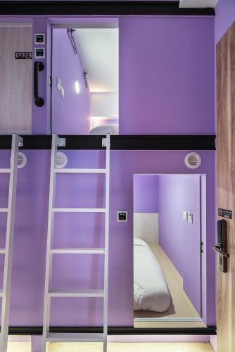 a purple bedroom with a bunk bed with a ladder at Owl Hostel 貓頭鷹旅店 in Yuchi