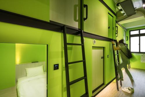 a room with a bunk bed and a ladder at Owl Hostel 貓頭鷹旅店 in Yuchi