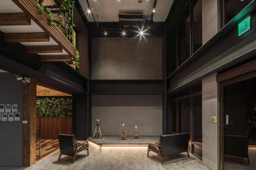 a lobby with two chairs and a table at Owl Hostel 貓頭鷹旅店 in Yuchi