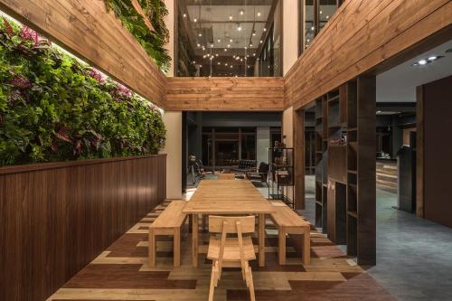 una mesa larga en un restaurante con plantas en las paredes en 貓頭鷹旅店 en Yuchi