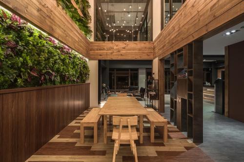 a long table in a restaurant with plants on the walls at Owl Hostel 貓頭鷹旅店 in Yuchi