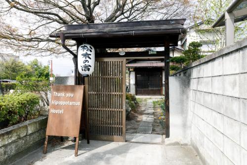 a entrance to a building with a sign in front of it at 古民家一棟貸しの宿 Thank you Hippo Inn in Matsumoto