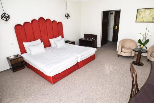 a large bed with a red headboard in a room at International Bucharest City Centre Hotel in Bucharest
