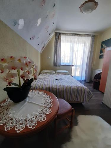 a bedroom with a bed and a table with flowers on it at Pokoje u Kordeckich in Niedzica Zamek