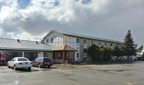 a building with two cars parked in a parking lot at Super 8 by Wyndham Cut Bank in Cut Bank