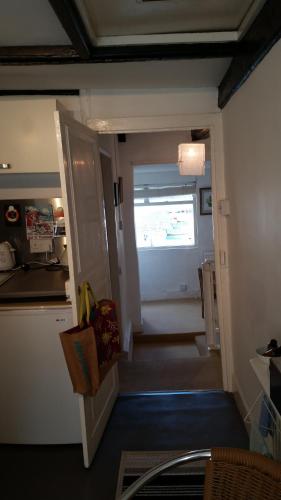 uma cozinha com uma escada que leva a um quarto com uma janela em Reed's of Fowey em Fowey