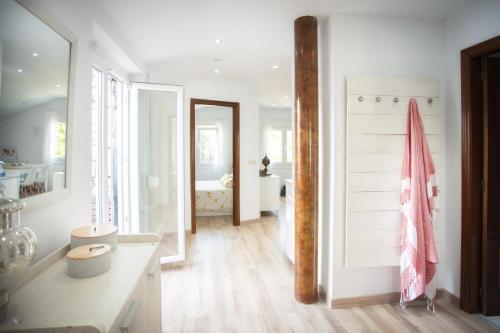 a bathroom with white walls and a wooden floor at Casa Blanco Vista Maravillosa in Compostela