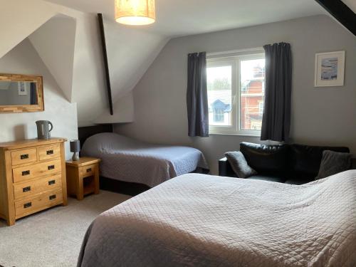 um quarto de hotel com duas camas e uma cadeira em Rivington House Room only em Whitby