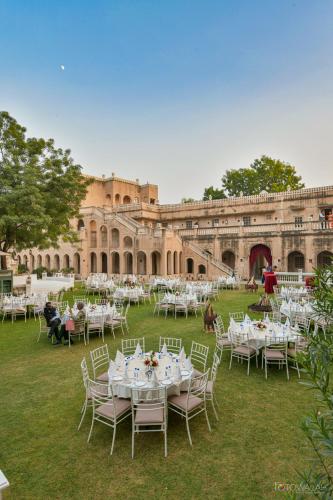 a group of tables and chairs in front of a building at Hotel Castle Mandawa in Mandāwa