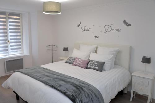a bedroom with a white bed with pillows on it at Petite Venise Gîte Saint Pierre 2 pièces 3 étoiles classement tourisme in Colmar
