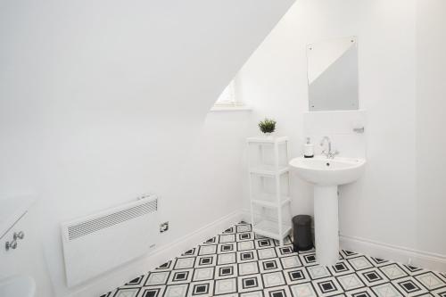 a white bathroom with a sink and a mirror at Canterbury 2 Bed Apartment Close to Town CT1 Sleeps 6 in Canterbury