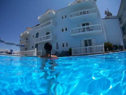 a person in the water in front of a building at Clear Horizon in Amoudi