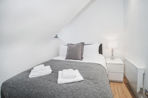 a bedroom with a bed with two towels on it at Canterbury 2 Bed Apartment Close to Town CT1 Sleeps 6 in Canterbury