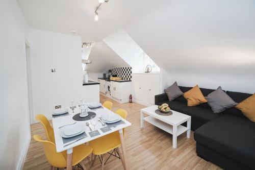 a living room with a black couch and a table at Canterbury 2 Bed Apartment Close to Town CT1 Sleeps 6 in Canterbury