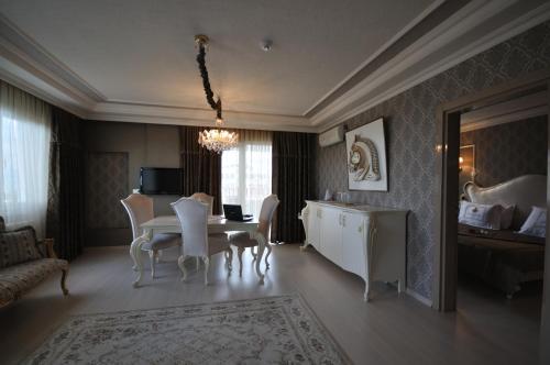 a living room with a table and chairs and a bedroom at Grand Atakum Hotel in Samsun