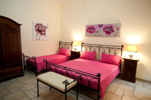 2 Betten in einem Zimmer mit rosa Bettwäsche in der Unterkunft B&B Anxa in Gallipoli