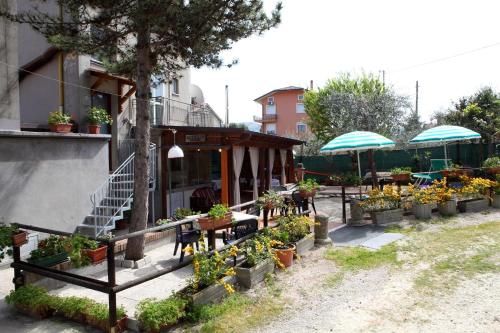 un patio con mesas, sillas y flores en ollas en Dallapia en Santa Maria del Piano