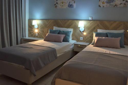 Un dormitorio con 2 camas y una ventana con luces. en Notos Villas, en Frangokastello