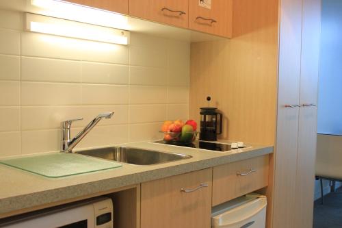 a kitchen with a sink and fruit on the counter at Waves in Orewa