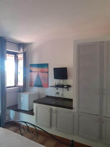 a bedroom with a bed and a tv on a desk at Alla Finestra Sul Parco in Cefalù