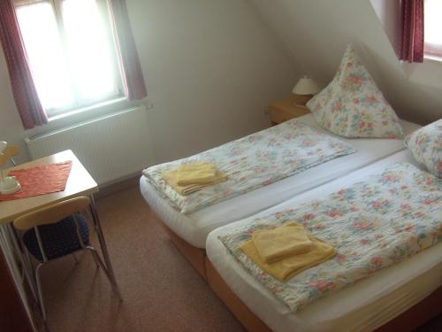 a bedroom with two beds and a desk and a window at Pension Becker in Rothenburg ob der Tauber
