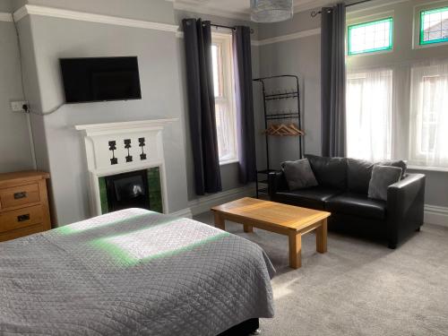 1 dormitorio con cama, sofá y chimenea en Rivington House Room only, en Whitby