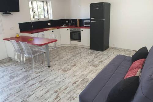 cocina con mesa y sofá en una habitación en Maisonnette A Bretignolles sur Mer 2 personnes en Brétignolles-sur-Mer