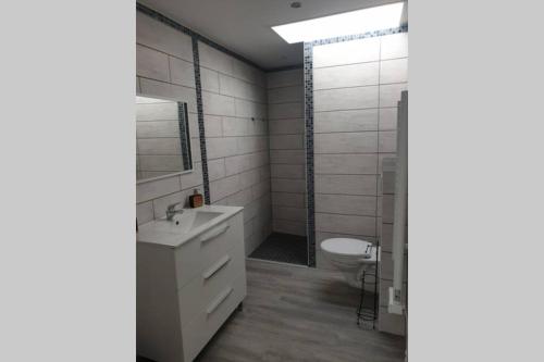 ein Badezimmer mit einem weißen Waschbecken und einem WC in der Unterkunft Maisonnette A Bretignolles sur Mer 2 personnes in Brétignolles-sur-Mer