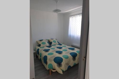 ein Schlafzimmer mit einem Bett mit einem Polka-Punktfolie in der Unterkunft Maisonnette A Bretignolles sur Mer 2 personnes in Brétignolles-sur-Mer