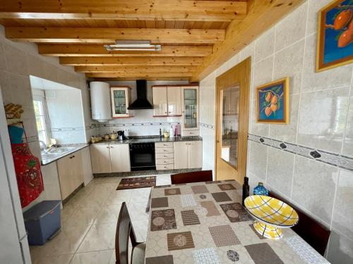 a large kitchen with a table and a stove at Casa Janeiro in Barreiros