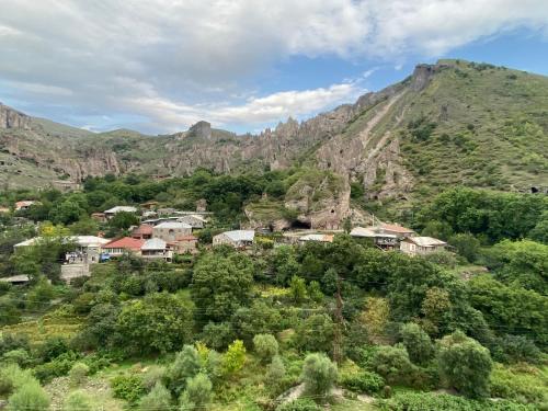 a village on a hill with mountains in the background at Christy Hotel in Goris