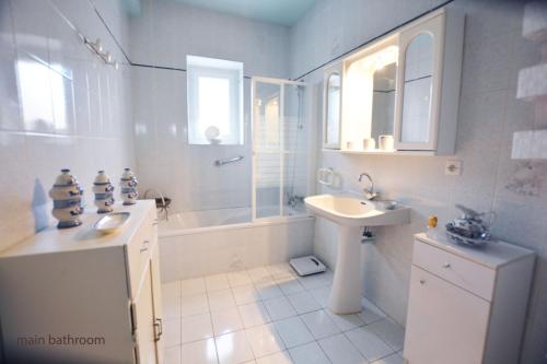 a bathroom with a sink and a tub and a toilet at La Petite Maison in Cesseras