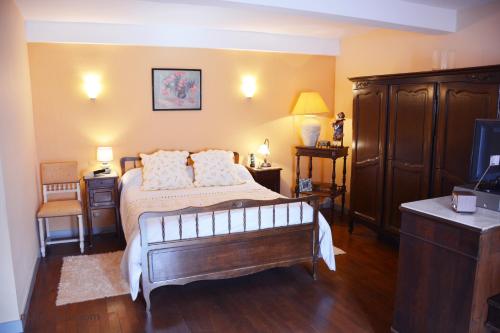 a bedroom with a bed and a tv in it at La Petite Maison in Cesseras