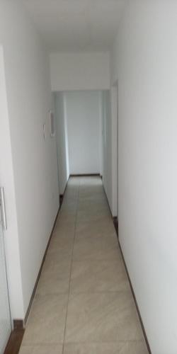 an empty hallway with white walls and a tile floor at Pousada Beach Claudia in Maragogi
