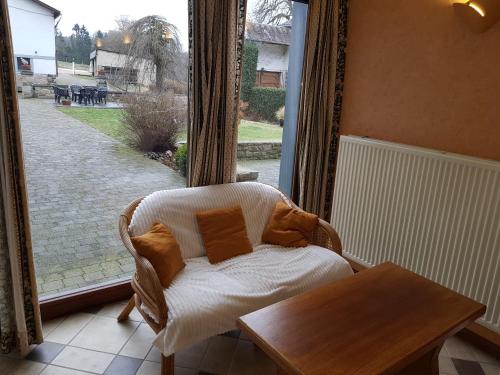 a room with a chair and a table and a window at La Source d'Arimont in Malmedy