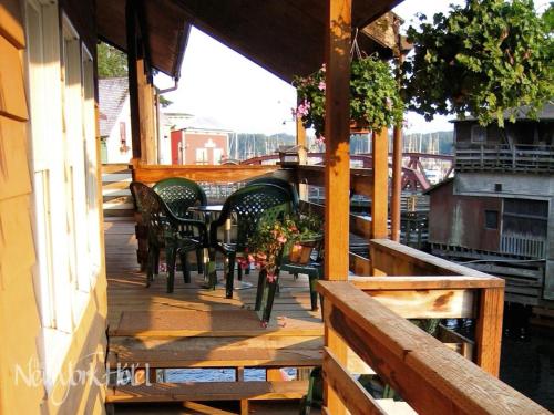 a porch with chairs and a table on a balcony at Inn At Creek Street in Ketchikan