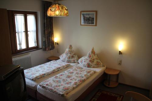 2 Betten in einem kleinen Zimmer mit Fenster in der Unterkunft Hotel Pension Becker in Rothenburg ob der Tauber