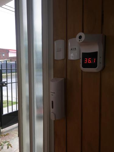 an alarm clock on a wall with a clock on it at Hostal Loreto Belen in Puerto Natales