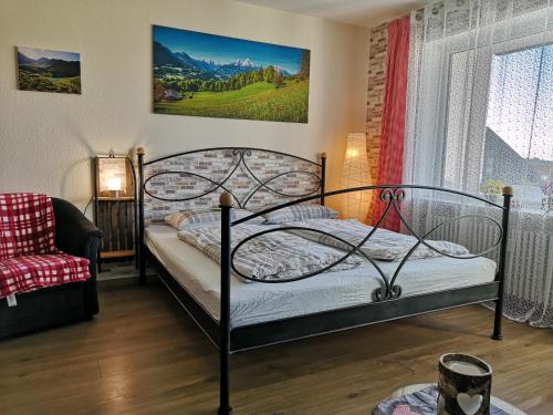 1 dormitorio con 1 cama, 1 silla y 1 ventana en Ferienwohnung Ausblick, en Missen-Wilhams