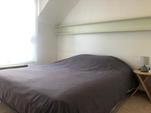 a bed in a bedroom with a large window at Trois-Épis, vue magnifique in Ammerschwihr