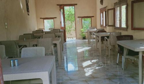 un restaurant vide avec des tables, des chaises et des fenêtres dans l'établissement Tunis King Hotel, 