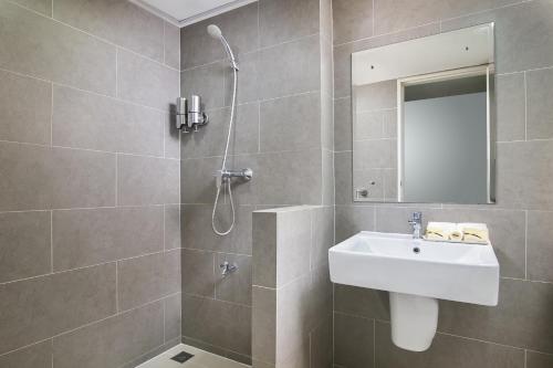 a bathroom with a sink and a shower at Chiva Bangkok Hotel - SHA Plus in Bangkok