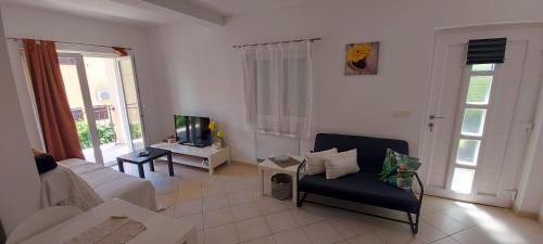 a living room with a couch and a tv at Apartmani Tomislav in Krk