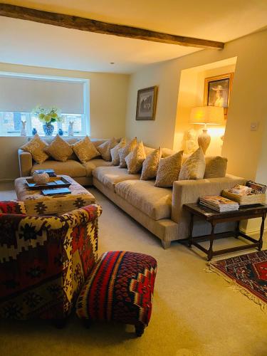 a living room with a couch and a table at Little Campden House in Chipping Campden