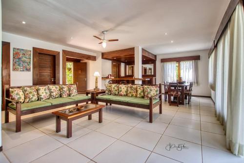 a living room with couches and a table at Domus Villas in Pipa