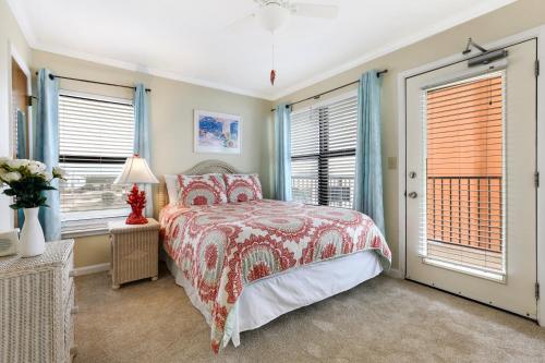 um quarto com uma cama e duas janelas em Island Sunrise 360 em Gulf Shores