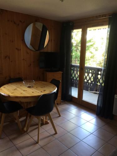 Un comedor con mesa y sillas y un balcón. en Manon, en Hauteluce