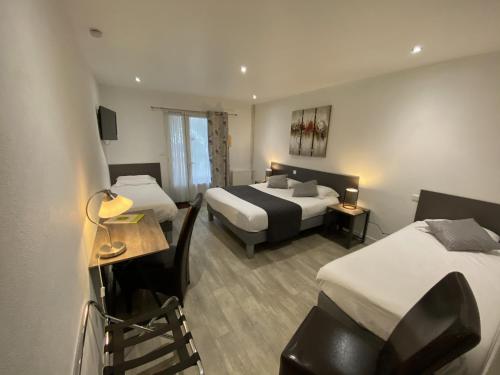 a hotel room with two beds and a table and a chair at Logis Hôtel L'Oliveraie in Cognac